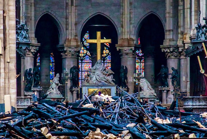 
A view of the cross and sculpture of Pieta by Nicolas Coustou with debris in the foreground Tuesday inside Notre-Dame de Paris, in the aftermath of a fire that devastated the cathedral in Paris. - Christophe Petit Tesson / Pool via Reuters
