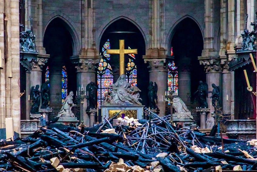
A view of the cross and sculpture of Pieta by Nicolas Coustou in the background of debris inside Notre-Dame de Paris, in the aftermath of a fire that devastated the cathedral. - Christophe Petit Tesson/Pool via REUTERS
