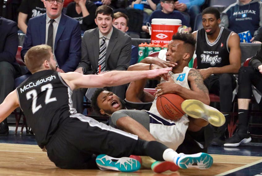 
 Halifax Hurricanes’ Joel Kindred (13) hangs on tight to the ball after fighting with Moncton Magic’s Wayne McCullough and Denzell Taylor early in the second quarter Monday night in Halifax. - Eric Wynne
