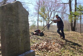 Ron Bezanson of the Burial Grounds Care Society in Kings County mulches leaves at the Robinson Cemetery in Brooklyn Corner Wednesday. The society locates, researches and cares for abandoned cemeteries in the county. - Ian Fairclough