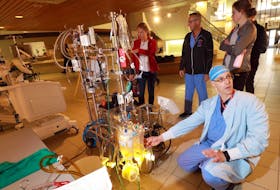 
Roger Stanzel, a cardiovascular perfusionist, demonstrates the machinery used during heart and lung surgeries in the lobby of the Infirmary Building on Summer Street. Perfusionists control the machines used to regulate blood flow and oxygen intake when surgeons render your heart or lungs temporarily inoperable. - Eric Wynne

