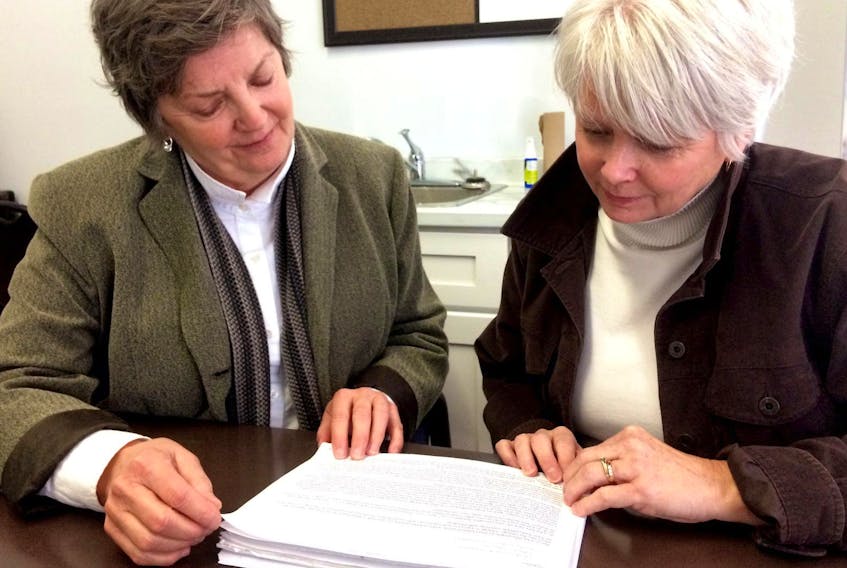 Joan Skinner, left, and Beth MacKenzie look over one of the emails they sent to Shannex regarding the care their late mother, Pat, was receiving at Northumberland Hall in Amherst. They believe their mother did not receive quality care.