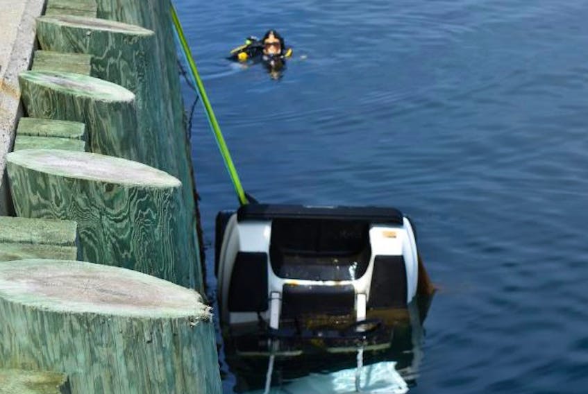 
A police diver helps recover a stolen golf cart near the government wharf in Canso. - RCMP photo
