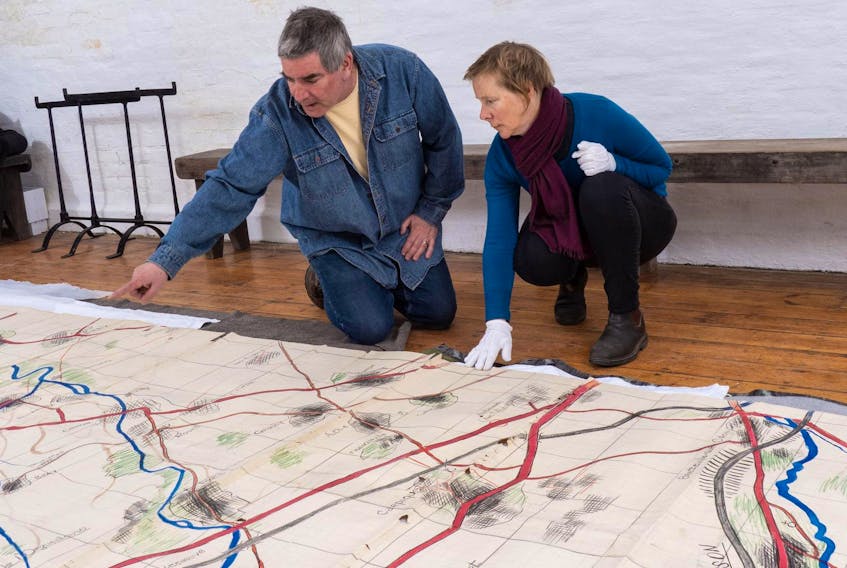 
Chara Kingston, registrar at the Army Museum Halifax Citadel, and Kevin Robins, the museum’s curator of military history, look over a large, fragile Second World War operations map that has been photographed and will be turned into a vinyl mural copy for display at the museum’s events this week marking the 75
th
 anniversary of the D-Day invasion of France. - Wally Hayes

