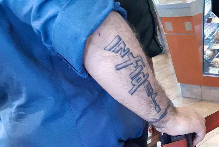 
The Royal Canadian Navy is looking to identify a sailor with the word infidel tattooed in the shape of a rifle on his arm. - Contributed
