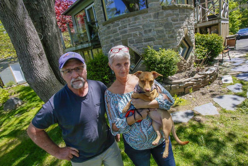 Steve and Katherine Deagle and pup, Grace, are seen outside their rental home in Purcell’s Cove on Monday. The couple, who are renting the basement suite of the home, are tired of the noise caused by the Airbnb being rented by the owner above them.