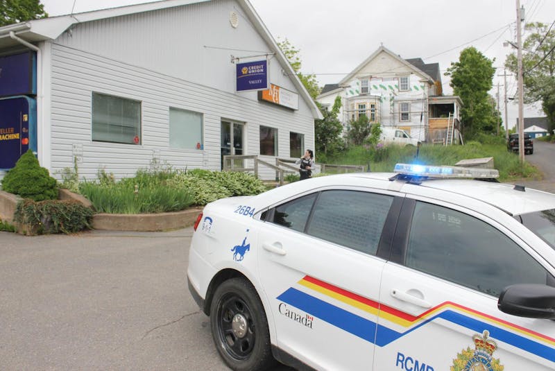 An RCMP officer stands outside the Valley Credit Union branch in Canning on June 14, 2019, after a shot was fired during an attempted armed robbery. - Ian Fairclough