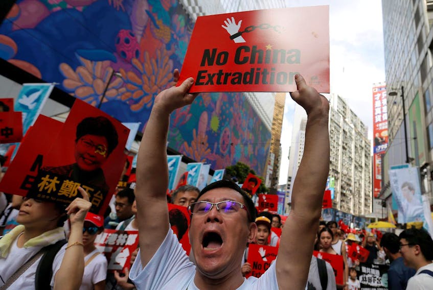 
A demonstrator holds up a sign on June 9 during a protest in Hong Kong to demand that authorities scrap a proposed extradition bill with China. - Thomas Peter/Reuters
