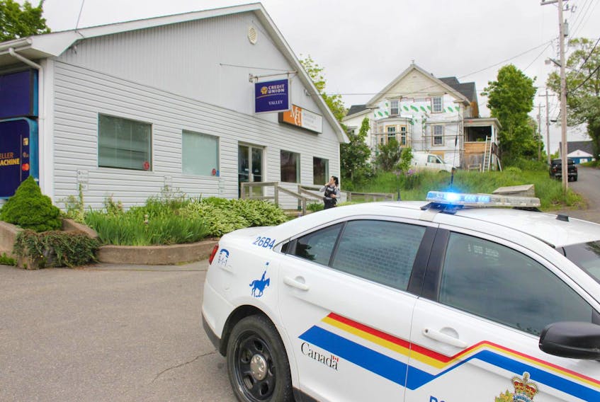
An RCMP officer stands outside the Valley Credit Union branch in Canning Friday morning following an armed robbery. 39-year-old Leif Spilchen is charged with multiple offenses, including committing a robbery with a firearm, in relation to the robbery. - Ian Fairclough
