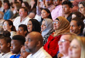 New Canadians listen to a speaker during an Immigration, Refugees and Citizenship Canada special citizenship ceremony with the Rainbow Refugee Association of Nova Scotia and the Halifax Central Library to celebrate Pride Month. - Tim Krochak