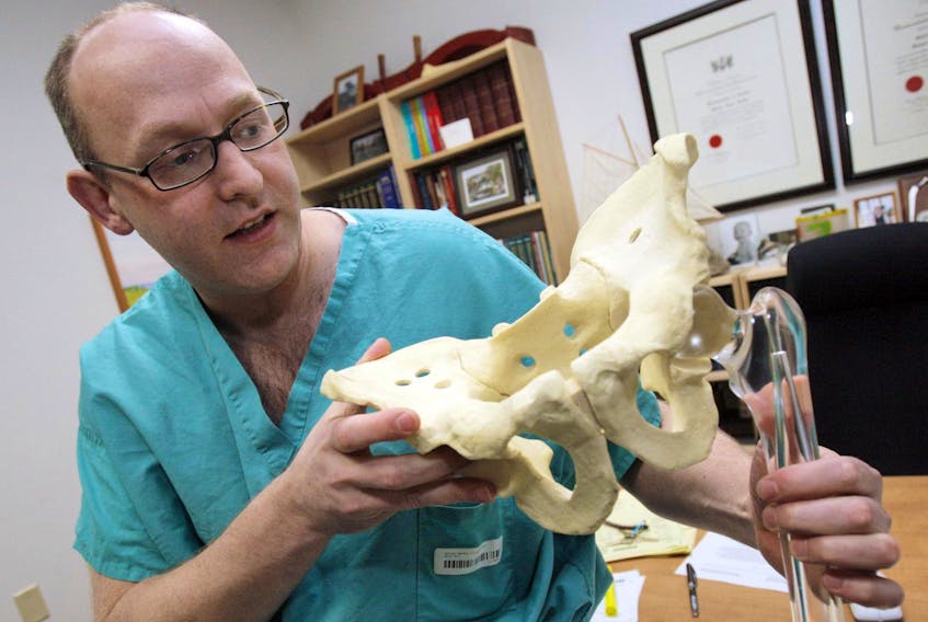 
Dr. Michael Dunbar explains the workings of a hip joint in his Halifax office in this file photo. - Herald file
