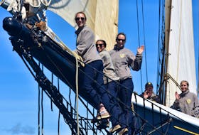 Bluenose II crew members wave goodbye from the bowsprit. - Josh Healey