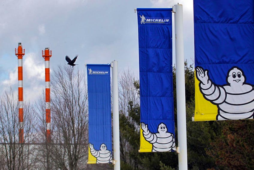 
A crow flies past flags lining the route into the parking lot the Michelin plant in Waterville on Jan. 17, 2012. - Tim Krochak / File
