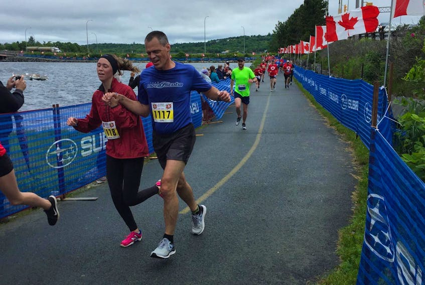 York Friesen approaches the finish line hand-in-hand with his daughter Jesse in the Canadian 5k as part of the Epic Triathlon in Dartmouth on Monday. - Bill Spurr