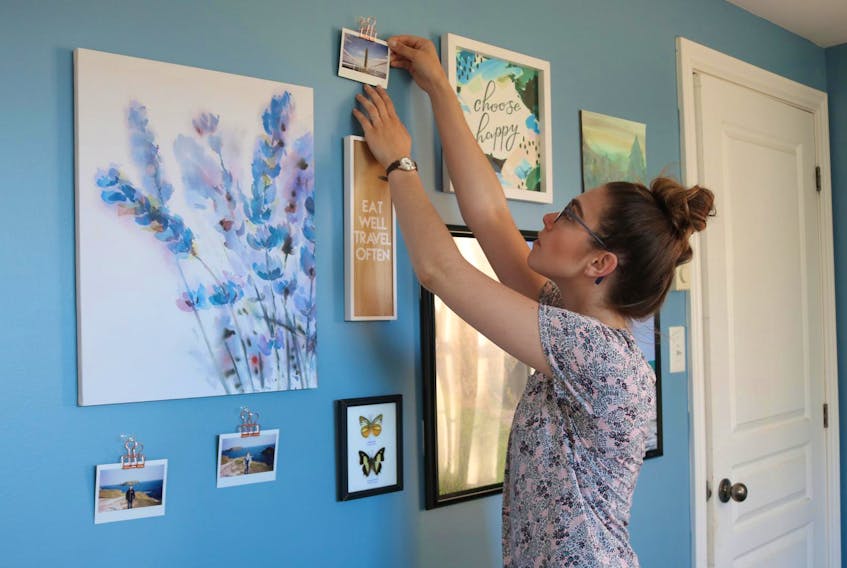 
Millee adjusts the angle of a Polaroid she displayed on her gallery wall by using miniature, clear command hooks and rose-gold coloured skeleton clips.
