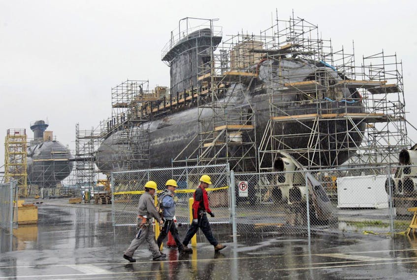 
Civililan defence workers walk past the scaffold-clad hulks of Canadian submarines, HMCS Chicoutimi, left, and HMCS Windsor, which underwent extensive work at HMC Dockyards in 2007. - Tim Krochak 
