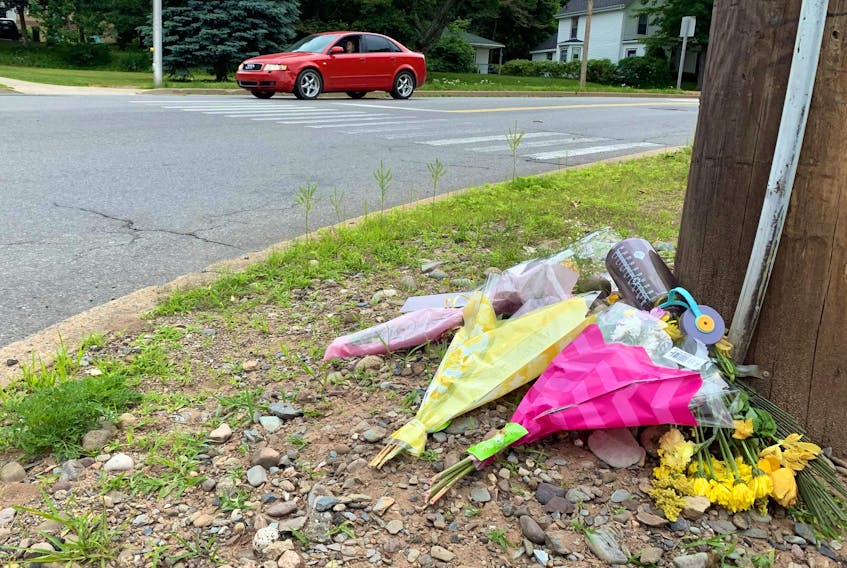 Flowers of remembrance are shown Friday near the Kentville crosswalk where a woman was struck by a truck and killed Tuesday morning.