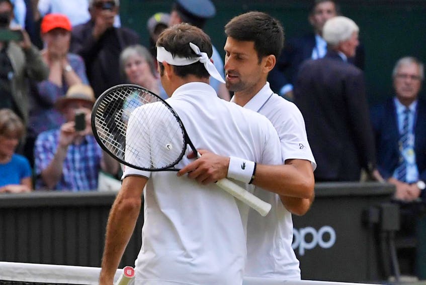 
Serbia’s Novak Djokovic and Switzerland’s Roger Federer embrace at the net after their historic five-set final at Wimbledon on Sunday, July 14, 2019. - Toby Melville / Reuters
