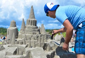 
Ian Brownrigg cleans up the edges of his group’s sandcastle at the 41st Clam Harbour Beach Sandcastle Competition on Sunday. NICOLE MUNRO
