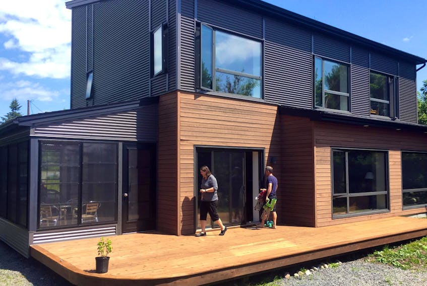 Designer of energy efficient homes, Natalie Leonard, owner of Passive Design Solutions, and homeowner Marcus Turner on the deck of Turner’s lakefront house in Hubley.