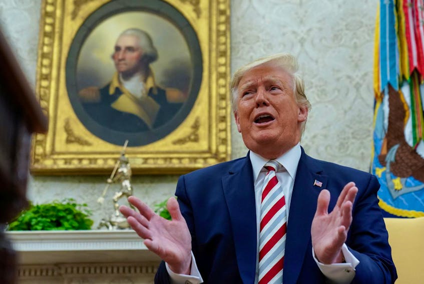 
U.S. President Donald Trump answers questions from reporters sitting in front of a portrait of former U.S. President George Washington on Tuesday. - Kevin Lamarque/Reuters
