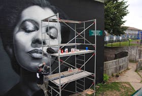 
Artist JEKS climbs scaffolding as he works on his mural of the late Nova Scotian opera star Portia White, on a building unit at Mulgrave Park in Halifax on Aug. 26. JEKS was one of 14 muralists and artists contributing to Paint in the Park 2019. 
