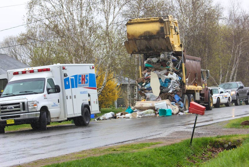 
An RCMP officer and Labour Department investigator talk at the scene of a workplace accident involving a garbage truck in Port Williams on May 10, 2018. - Ian Fairclough

