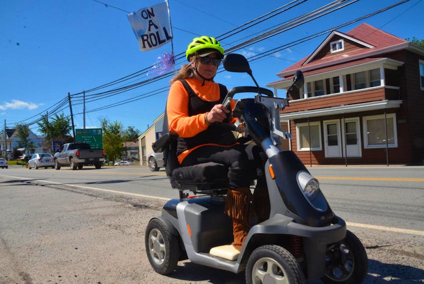 
Sonja Wood rolls through Shubenacadie en route to Ottawa aboard her electric scooter to call on Fisheries and Oceans Canada to allow free fish passage through causeways. - Aaron Beswick
