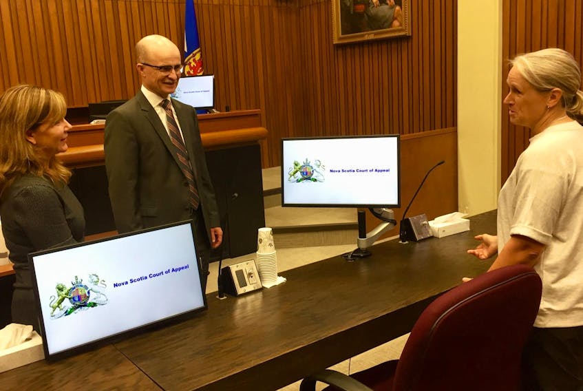 
Kelly Burke, right, a senior technical analyst with the provincial Internal Services Department, explains technological improvements to Courtroom 502 at the Halifax Law Courts to Jennifer Glennie, executive director of court services for the Justice Department, and Michael Wood, chief justice of Nova Scotia. - Steve Bruce
