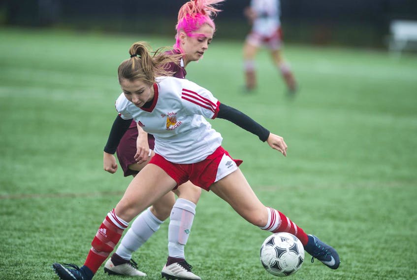 Sir John A. Macdonald Flames’ Virginia Boone keeps the ball away from Citadel Phoenix’s Faye Little during a metro high school girls’ soccer game at Mainland Common on Tuesday.
