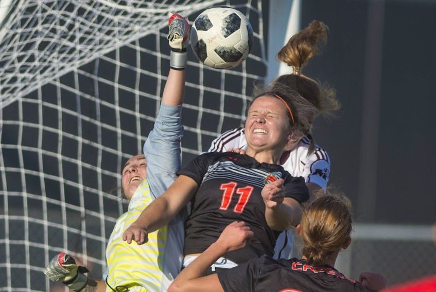 
Saint Mary’s Huskies keeper Grace Morrison, left, punches away the ball as Cape Breton Capers’ MacKenna King puts on the pressure during Friday night’s AUS women’s soccer game at Huskies Stadium. Ryan Taplin - The Chronicle Herald

