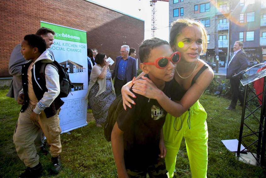 
Youngsters leave after posing for a photo with dignitaries after the announcement of a loan to build a new kitchen for the Hope Blooms community garden in north-end Halifax. 
