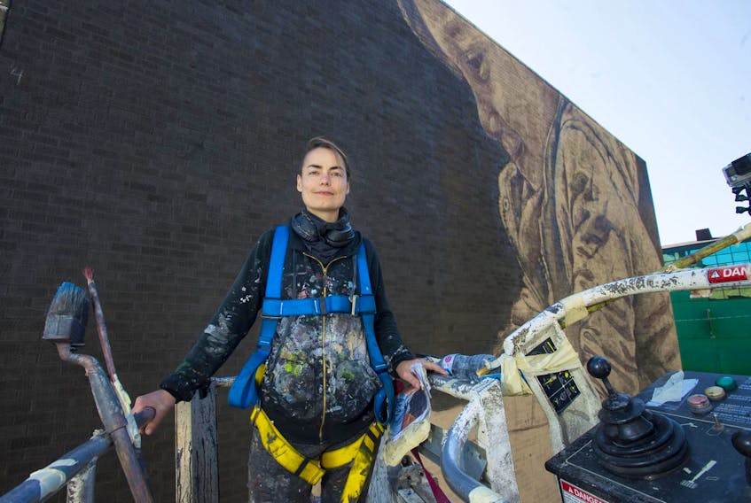 
From her perch in a cherry picker above Hollis Street, artist Jacoba Niepoort poses for a photo in front of a mural she’s creating in downtown Halifax on Thursday afternoon, Sept. 26, 2019. - Ryan Taplin 
