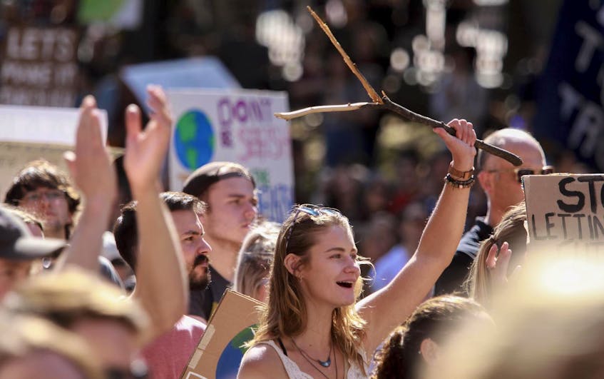 A climate strike demonstrator raises a dowsing rod over her head during a rally at the Grand Parade after a march through Halifax on Sept. 9, 2019. "Young people are often criticized for our apathy about politics. It’s true that voter turnout is often lower among youth. ...  Young people may participate in politics in informal ways, such as activism and volunteering, instead of voting," writes Eleanor Willner-Fraser. - Tim Krochak / File