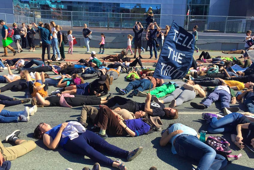 
Climate change protesters stage a die-in outside the Nova Scotia Power building on Lower Water Street in Halifax on Friday. 
