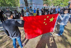 
Protesters fighting for justice for the citizens of Hong Kong form a human chain along the fence that surrounds the Halifax Public Gardens on Saturday afternoon while those opposed to the protesters’ views hold a Chinese flag in front of them. 
