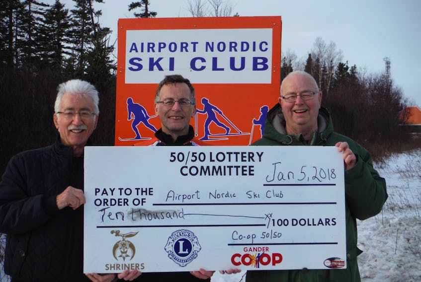 Jack Waye and Jeremy Decker of the Airport Nordic Ski Club accept a $10,000-contribution from Gerald Saunders of the Gander Co-Op to assist with the trail lighting system.