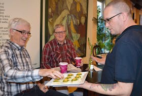 Trevor Pharoah, right, with Beanz Espresso Bar and Café in Charlottetown serves customers Frank MacDonald, left, and Ronald McInnis come gourmet complimentary snacks during happy hour on Thursday. DAVE STEWART/THE GUARDIAN