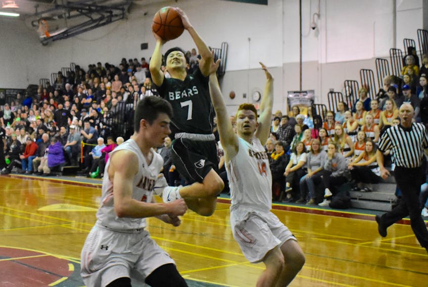 Tsukasa Ikuta of the Breton Education Centre Bears, middle, jumps to the basket as Jordin Rusnack, left and Brendon McCubbing of the Yorkton Raiders defend during New Waterford Coal Bowl Classic action at the BEC gym on Tuesday. The Bears won the game 73-69.