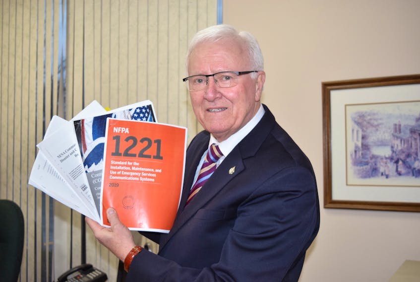Cumberland Colchester MP Bill Casey displays the reports he has read that all recommend against having a major communications centre operated from a single site.
