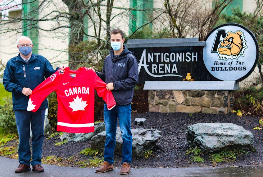 Arnie Farrell of Hockey Nova Scotia presents Andrew Boyle with his Hockey Canada Champion jersey outside the Antigonish Arena. Britt Pigat/Hockey Canada Images