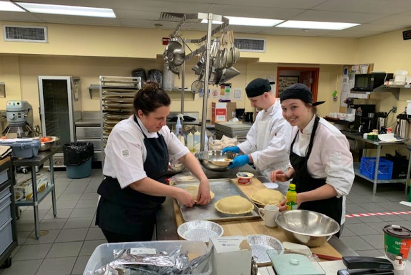 Chef Katie Hayes and students Meagan Mullowney and Colby Chaulk helped prepare 100 apple pies on Dec. 19 for a special project of the SaltWater Community Association.