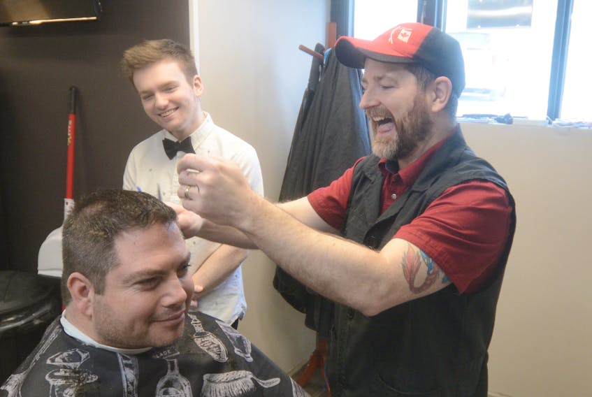 Tim Fahey shares a laugh with his son Zach and customer Bill Peterson at Tim’s Barber Shop in Amherst. Zach will soon start an apprenticeship as a barber under the watchful eye of his father.