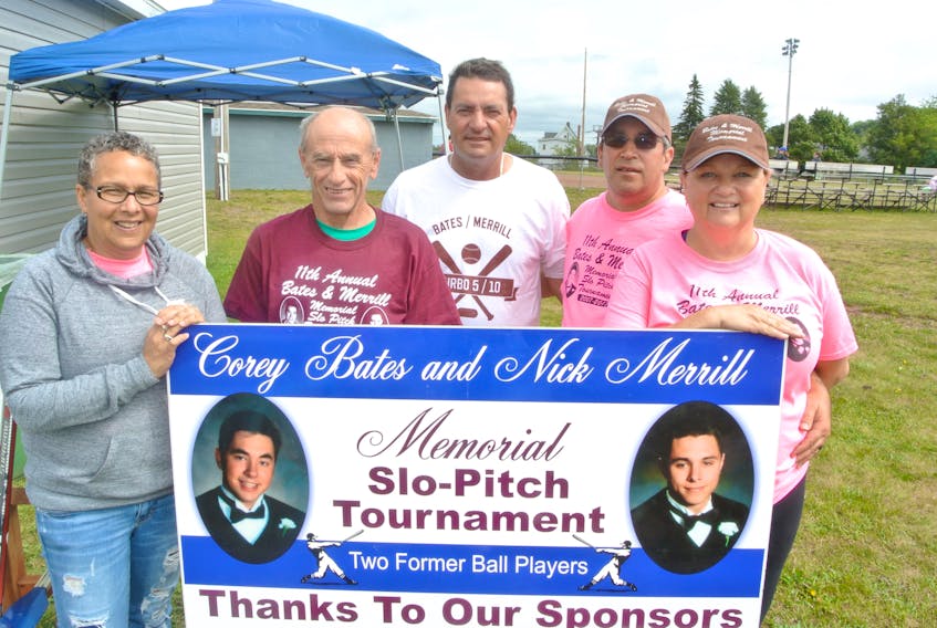 Holding up the Corey Bates and Nick Merrill Memorial Slo-Pitch Tournament banner are: (from left) Brenda and Ian Merrill, Jim Bates, Ron Lake and Kathy Lake.