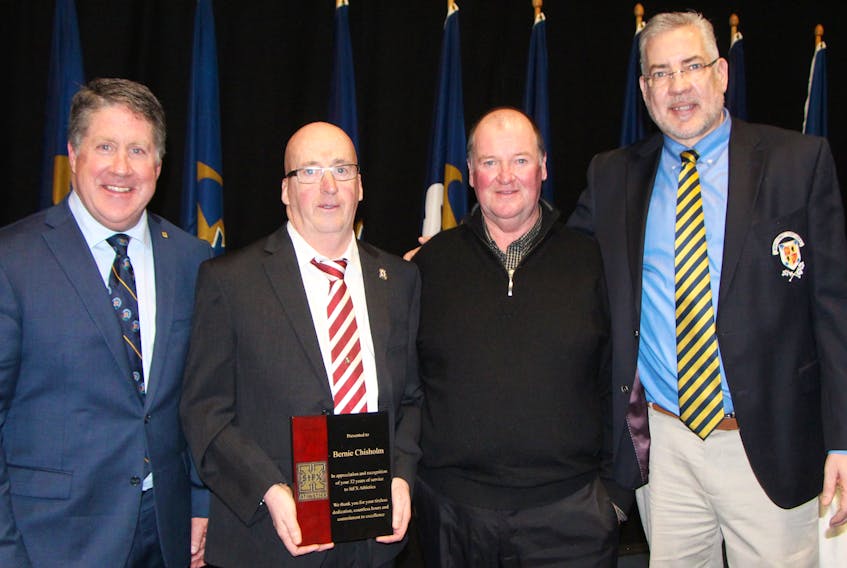 Long-time St. F.X. cross country and track and field coach Bernie Chisholm (second from left) being honoured during the university’s athletic awards banquet April 4. An opportunity for the community to honour Chisholm will come during Antigonish Highland Games weekend July 6 to 8. Pictured with Chisholm, during the athletics banquet, are St. F.X. President Kent MacDonald, Chisholm, long-time assistant coach Kevin Grant and athletic director Leo MacPherson.