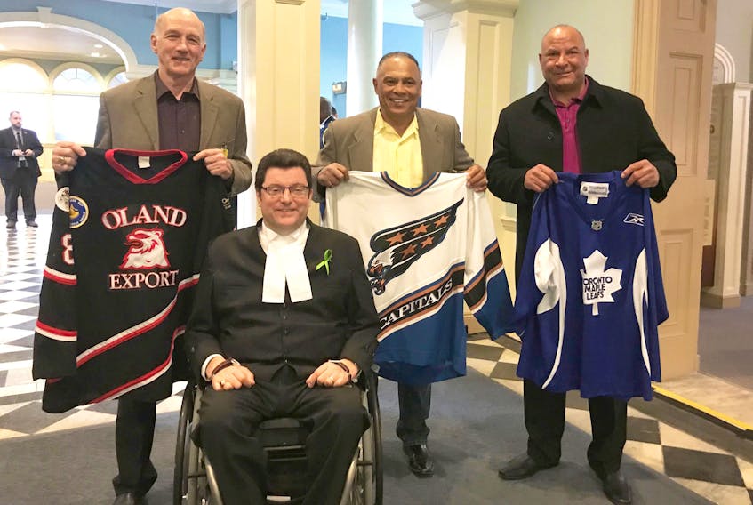 Amherst’s Bill Riley, centre, the first African-Nova Scotian and the third African-Canadian to play in the NHL, was one of many dignitaries who donned hockey jerseys during a memorial ceremony held at Province House earlier this year in Halifax. Accompanying Riley to the ceremony was his friend Jim Bottomley, left, who is also a former coach of the Amherst Ramblers; his cousin Jim Dorrington, who played hockey on a pond between their homes when they were kids growing up in Amherst; and Kevin Murphy, Speaker of the House at the Nova Scotia House of Assembly.
