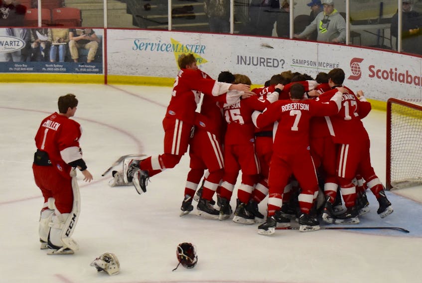 Members of the Riverview Redmen celebrate after defeating the Dartmouth Spartans 3-0 in the championship game of the Sydney Academy Blue and White Contractor Cup tournament on Sunday in front of about 300 spectators at the Membertou Sport and Wellness Centre. The Redmen punched their ticket to the final after defeating the host Wildcats 5-3 in one of Saturday’s semifinal matches