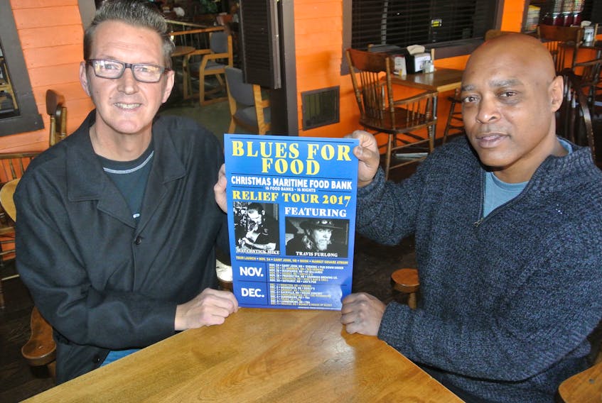 Matchstick Mike Bidlake (left) and Raymond Jones of Teazer’s Pub look over a poster for a Blues for Food tour that will raise money for food banks across the Maritimes, including Amherst.
