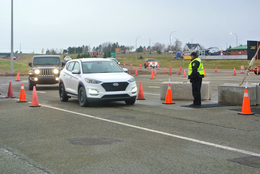 A conservation officer checks a vehicle entering the province at the Fort Lawrence COVID-19 control point. Cumberland County leaders want the province to rethink a plan to move the control point away from the inbound weigh station to Highway 104.