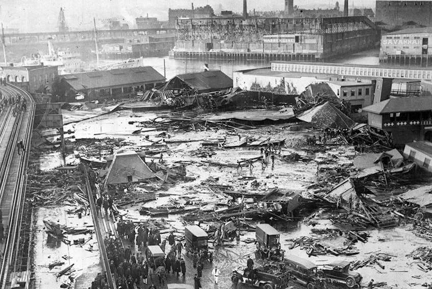 Twenty one people were killed on Commercial Street in the North End when a tank of molasses ruptured and exploded. An eight foot wave of the syrupy brown liquid moved down Commercial Street at a speed of 35mph. Wreckage of the collapsed tank visible in background, center, next to light colored warehouse. Elevated railway structure visible at far left and the North End Park bathing beach to the far right. - Wikimedia Commons